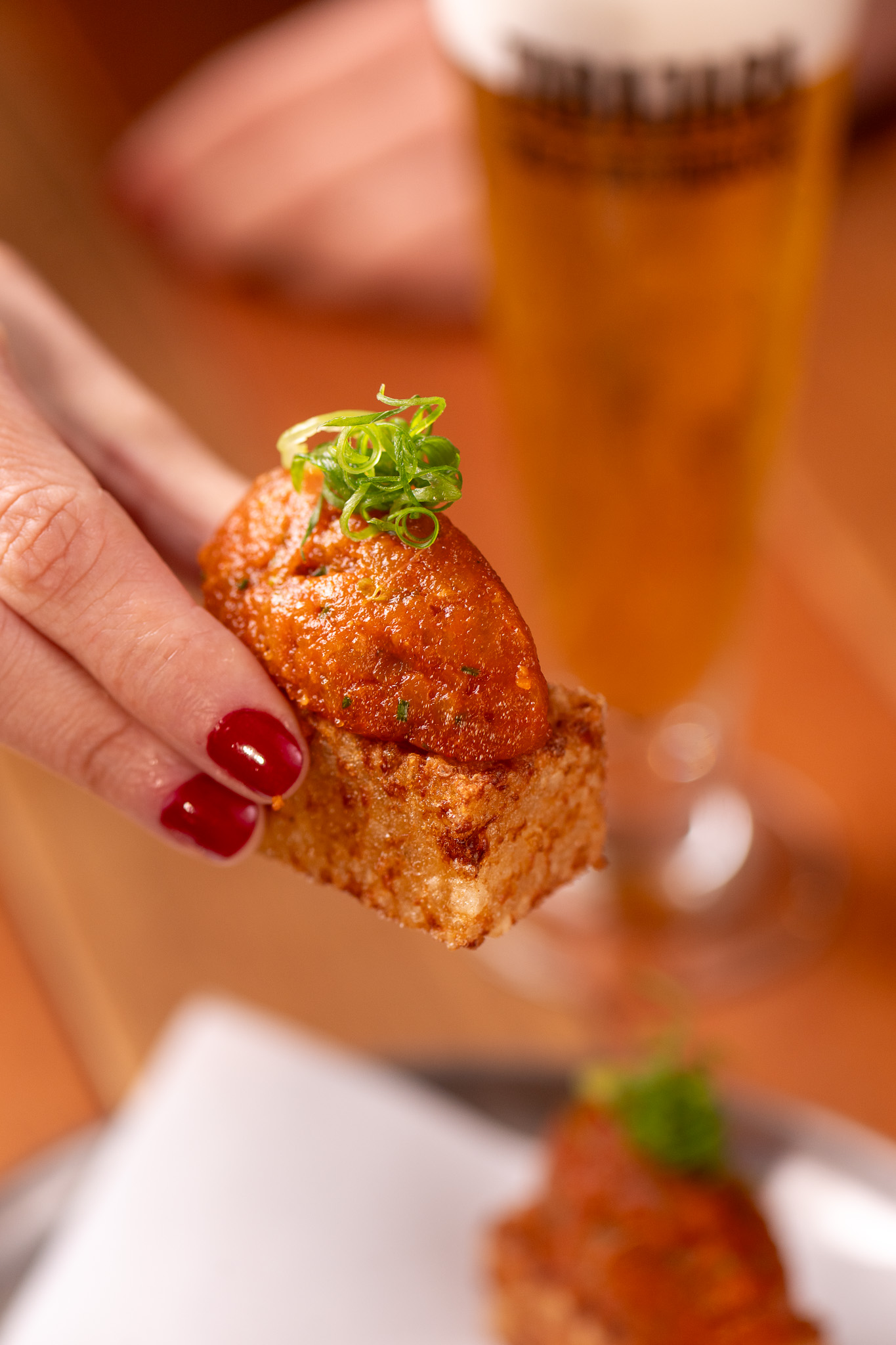 Croqueta da casa com tulipa de chopp ao fundo